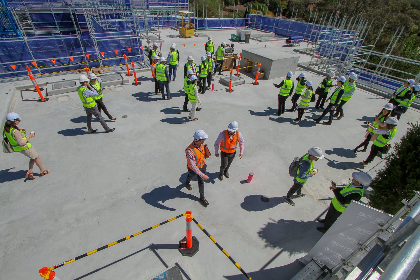 Professionisti edili ispezionano lavori sul tetto con ponteggi.