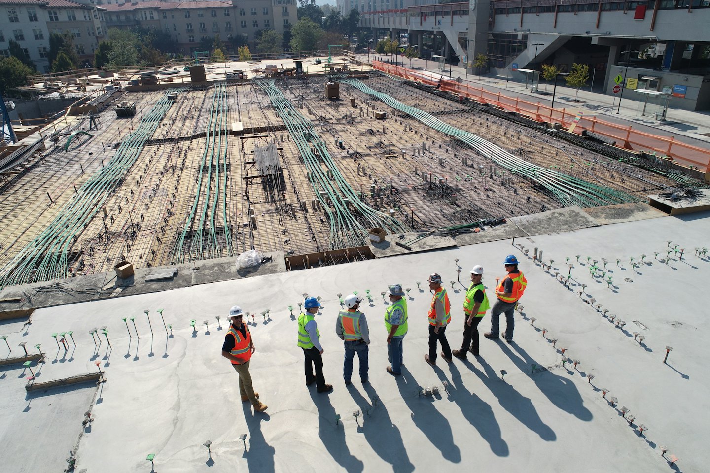 Operai edili in giubbotti di sicurezza osservano un cantiere.